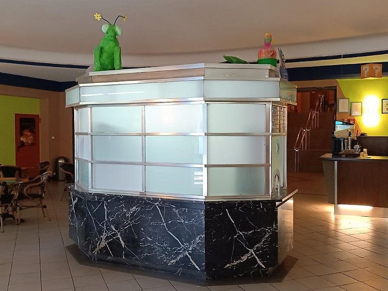Foyerbereich im Kino, mit einem alten Kassenhäuschen und Sitzgelegenheiten 