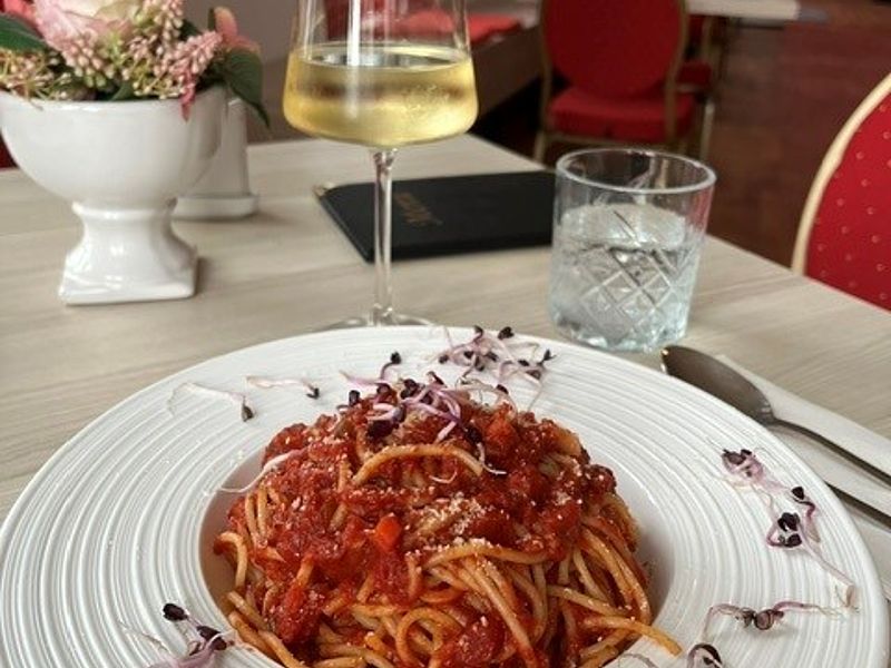 Hauptgang - Pastagericht, Spaghetti mit Tomatensauce, Glas Weißwein & Wasser, gedeckter Tisch